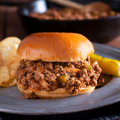 Sloppy Joe with potato chips and a pickle